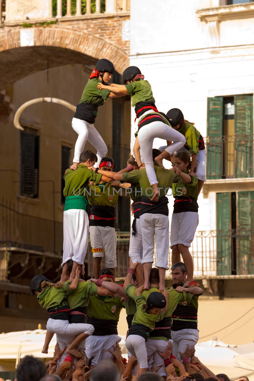 VERONA, ITALY - SEPTEMBER 19, 2015: Tocati, International festival of street games. Castells Performance of Xiquets d'Alcover of Tarragona, Catalonia, Spain. The Castells (Castle) is a human tower - UNESCO cultural heritage