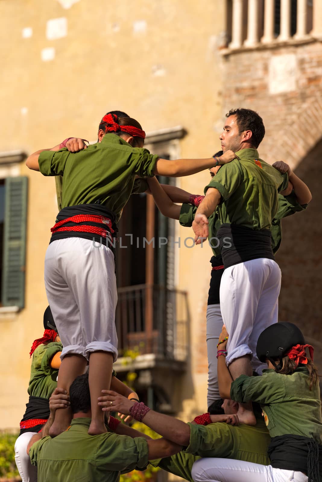 VERONA, ITALY - SEPTEMBER 19, 2015: Tocati, International festival of street games. Castells Performance of Xiquets d'Alcover of Tarragona, Catalonia, Spain. The Castells (Castle) is a human tower - UNESCO cultural heritage