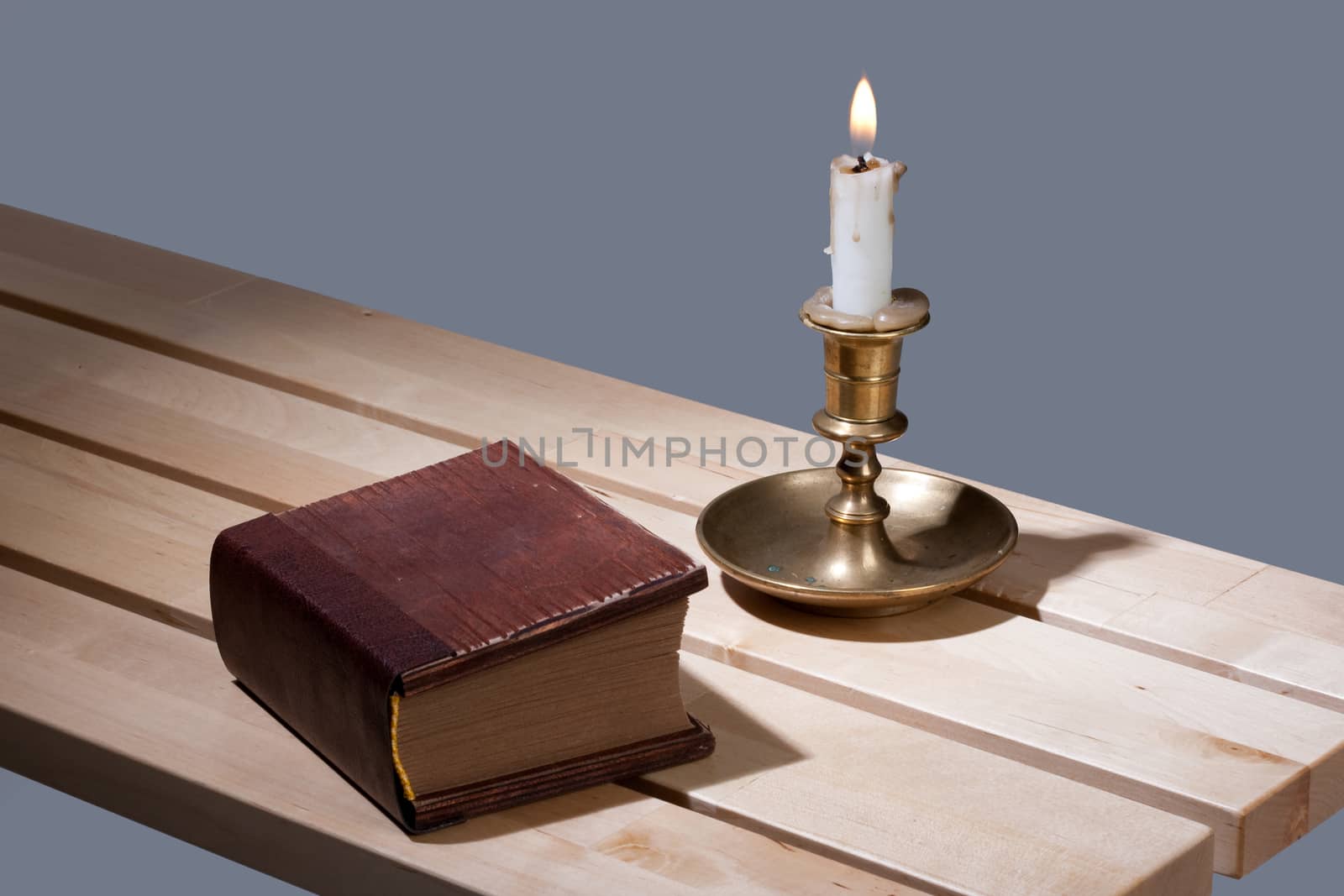 Old book and candle in an old candlestick