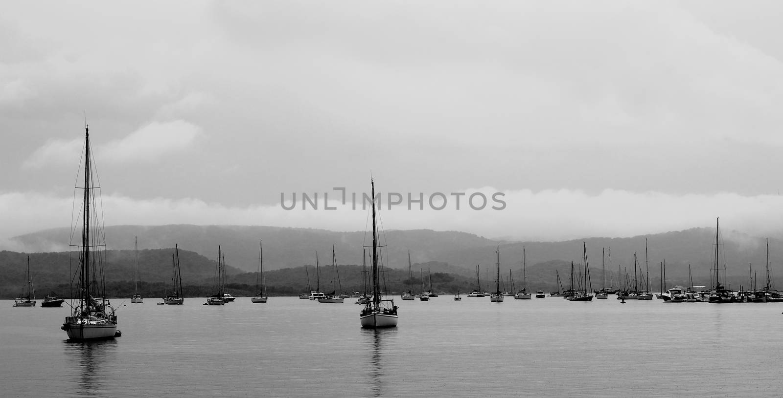 Parking of Small Yacht in Cloudy and Rainy Day near Menorca Coast, Balearic Islands. Black and White Toned