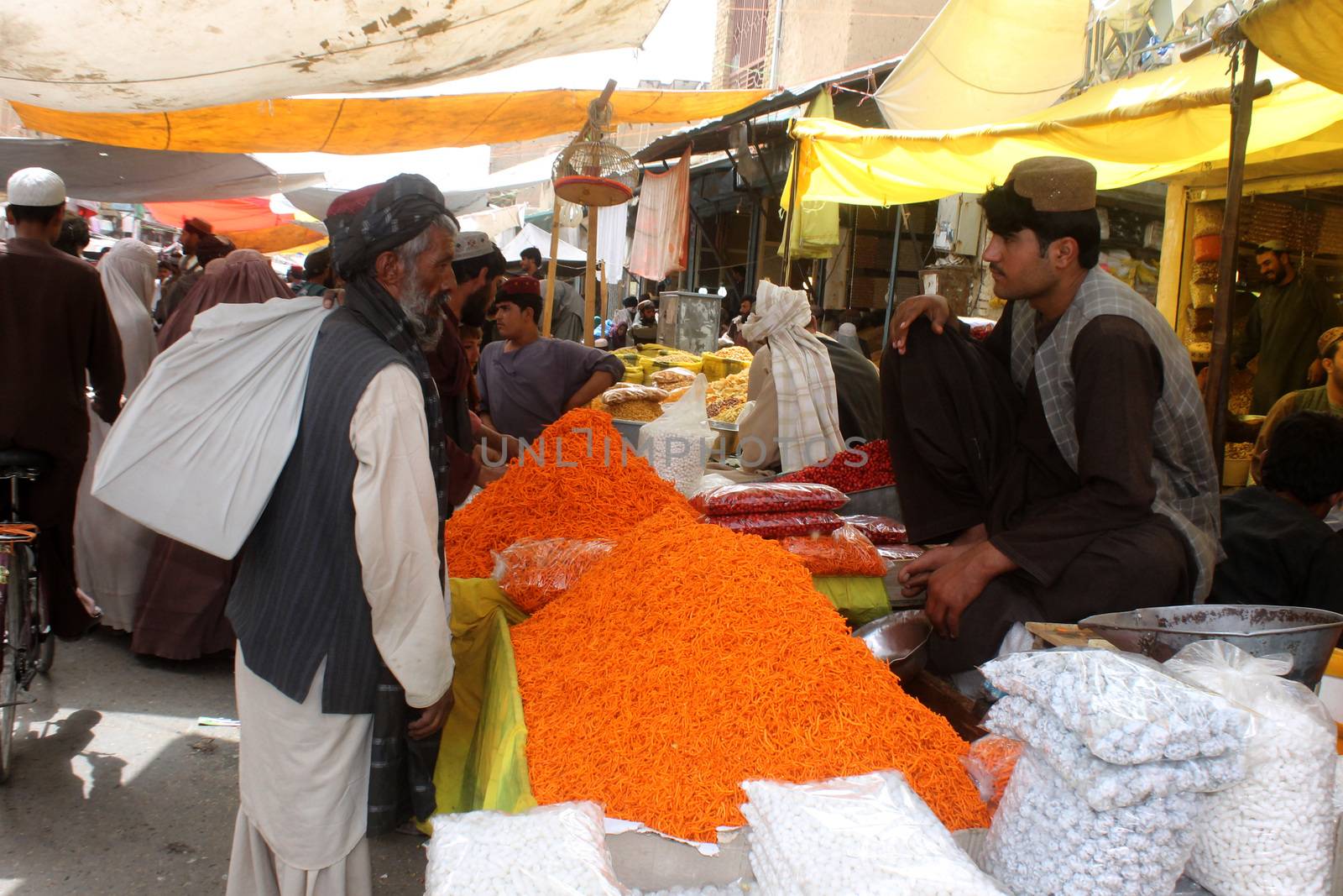 AFGHANISTAN, Kandahar: Crowds are out shopping in Charso Bazaar for Eid on September 22, 2015. Men in traditional dress and women in burqas buy dried fruits, biscuits, clothes, shoes, hats and things for their homes in Charso Bazaar, Kandahar. 