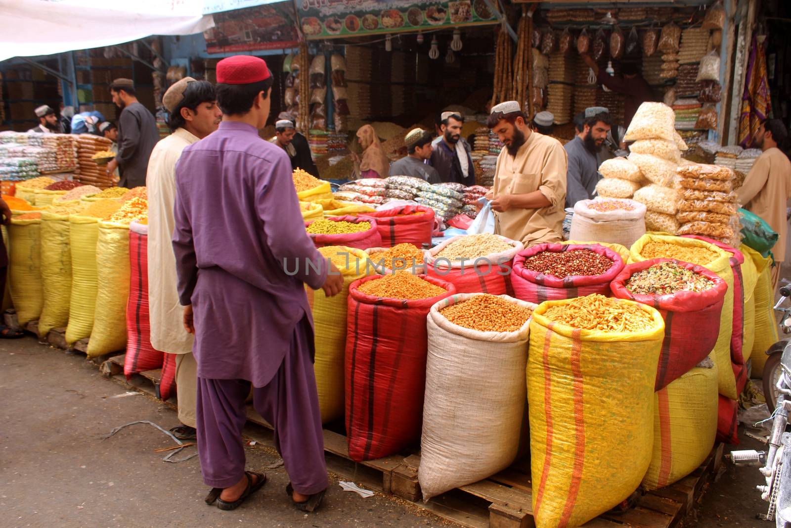 AFGHANISTAN, Kandahar: Crowds are out shopping in Charso Bazaar for Eid on September 22, 2015. Men in traditional dress and women in burqas buy dried fruits, biscuits, clothes, shoes, hats and things for their homes in Charso Bazaar, Kandahar. 