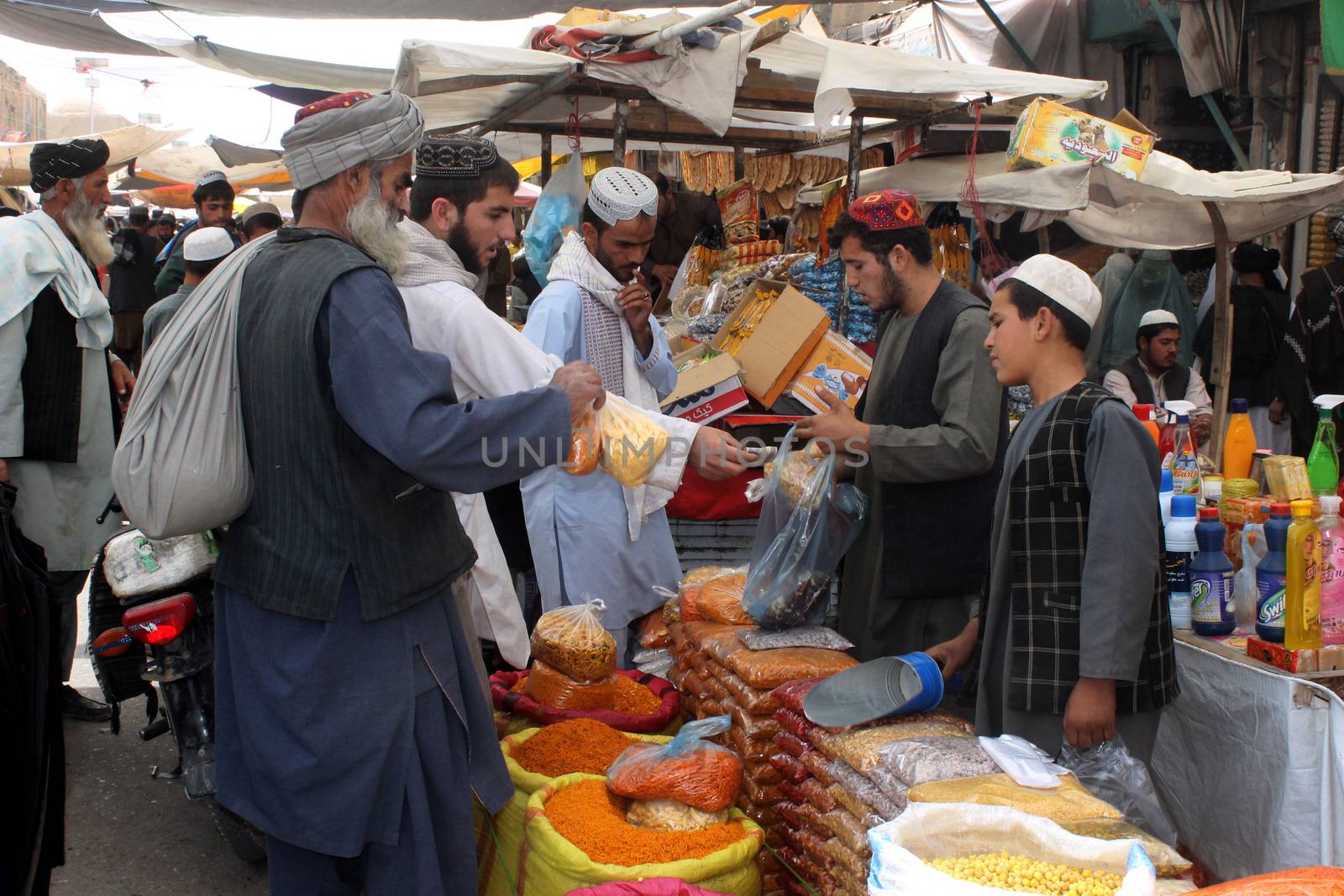 AFGHANISTAN, Kandahar: Crowds are out shopping in Charso Bazaar for Eid on September 22, 2015. Men in traditional dress and women in burqas buy dried fruits, biscuits, clothes, shoes, hats and things for their homes in Charso Bazaar, Kandahar. 