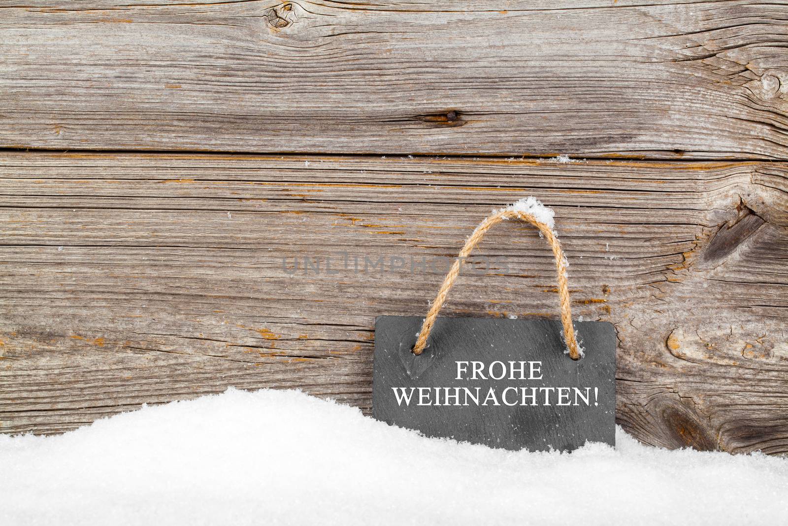 Black board of slate on old rustic wooden background, with snow