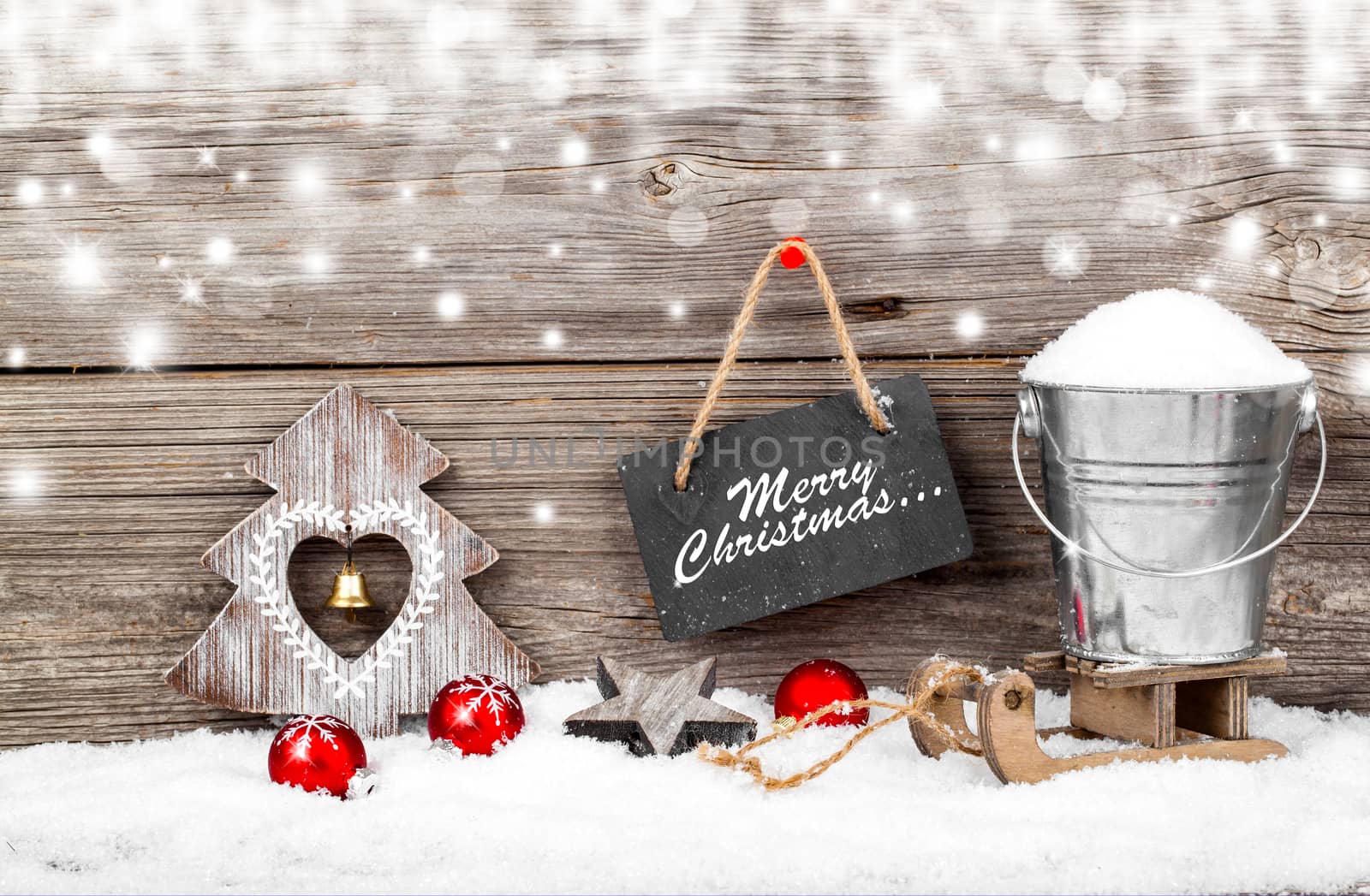 Snow in a bucket on a sled, on wooden background, with Christmas decoration