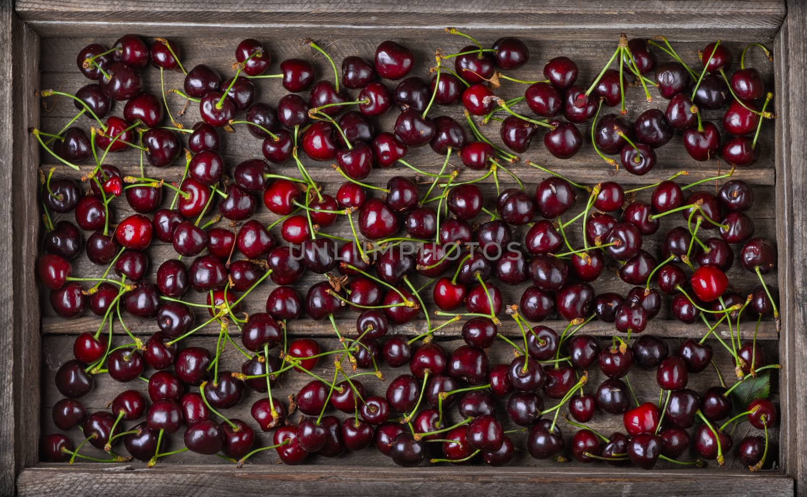 Harvest. Ripe sweet tasty cherry in an old wooden box, top view.  