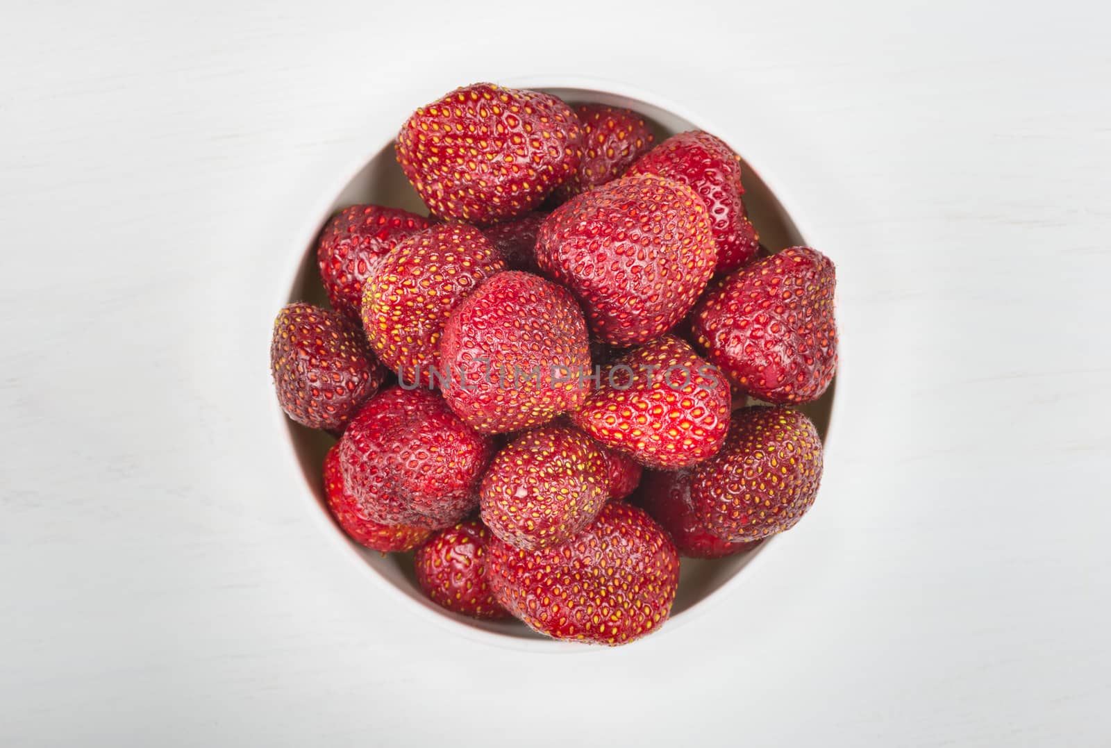 healthy rustic raw strawberries in white bowl
