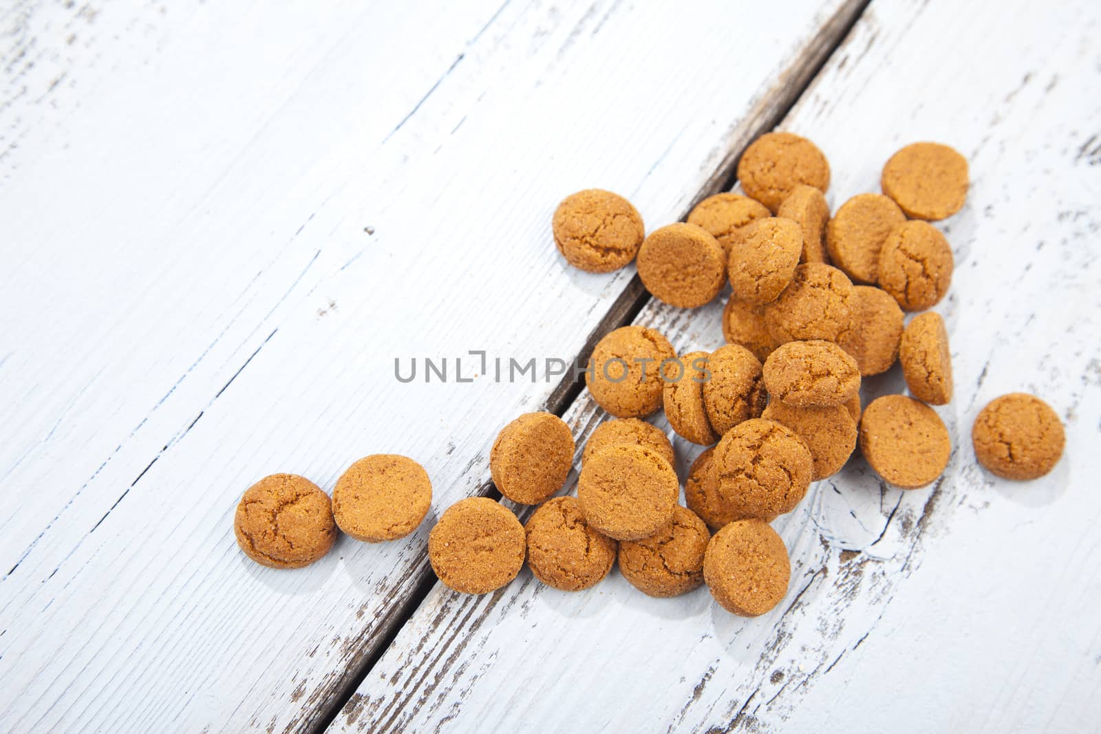 Pile of Dutch candy pepernoot on white wooden background