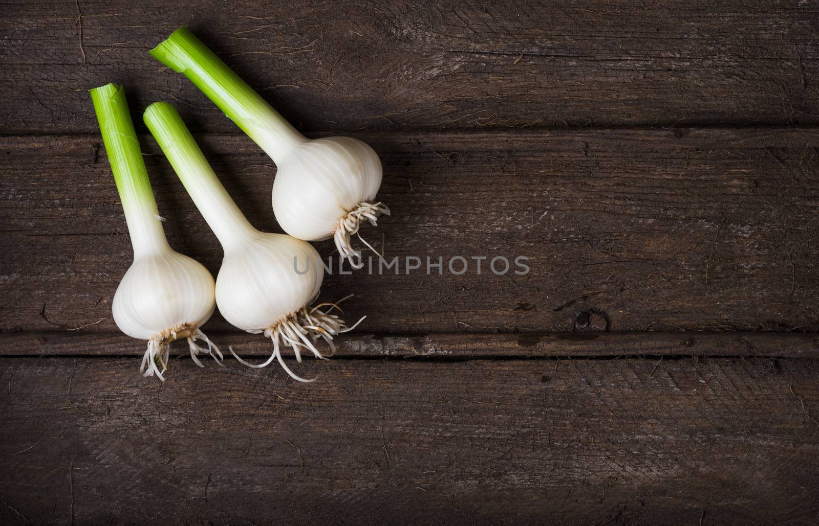 Fresh young garlic in an old wooden box top view close up