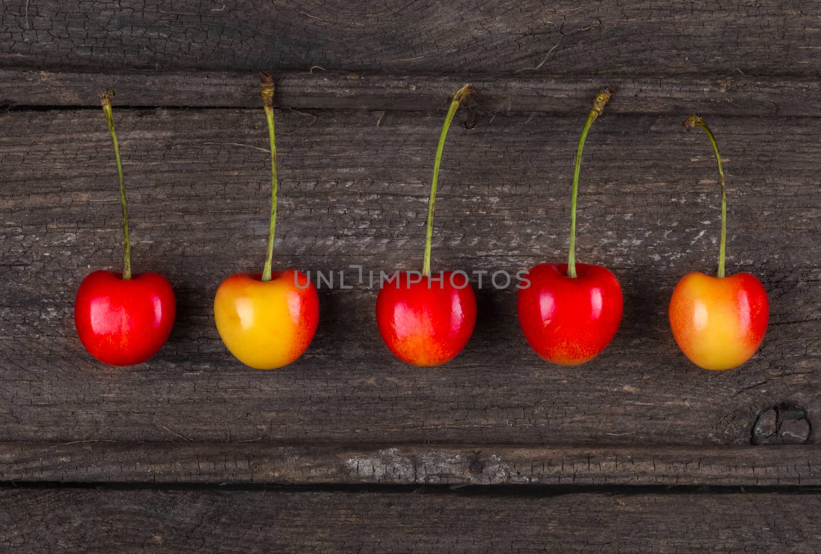 Harvest. Set of ripe sweet tasty cherry in an old wooden box, top view, close up. Breakfast for raw foodists.