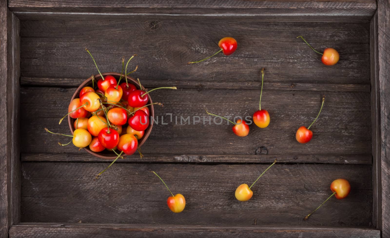 Harvest. Ripe sweet tasty cherry in an old wooden box, top view.  Breakfast for raw foodists.