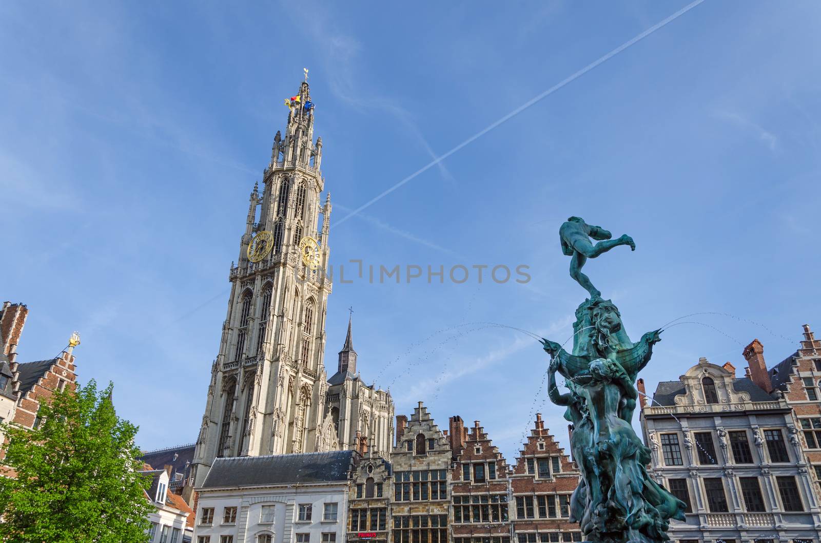 Statue of Brabo, throwing the giant's hand into the Scheldt River and the Cathedral of our Lady at Grand Place in Antwerp, Belgium. 