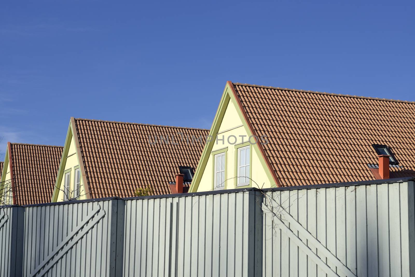 Photograph of a new house rooftop against a clear blue sky.