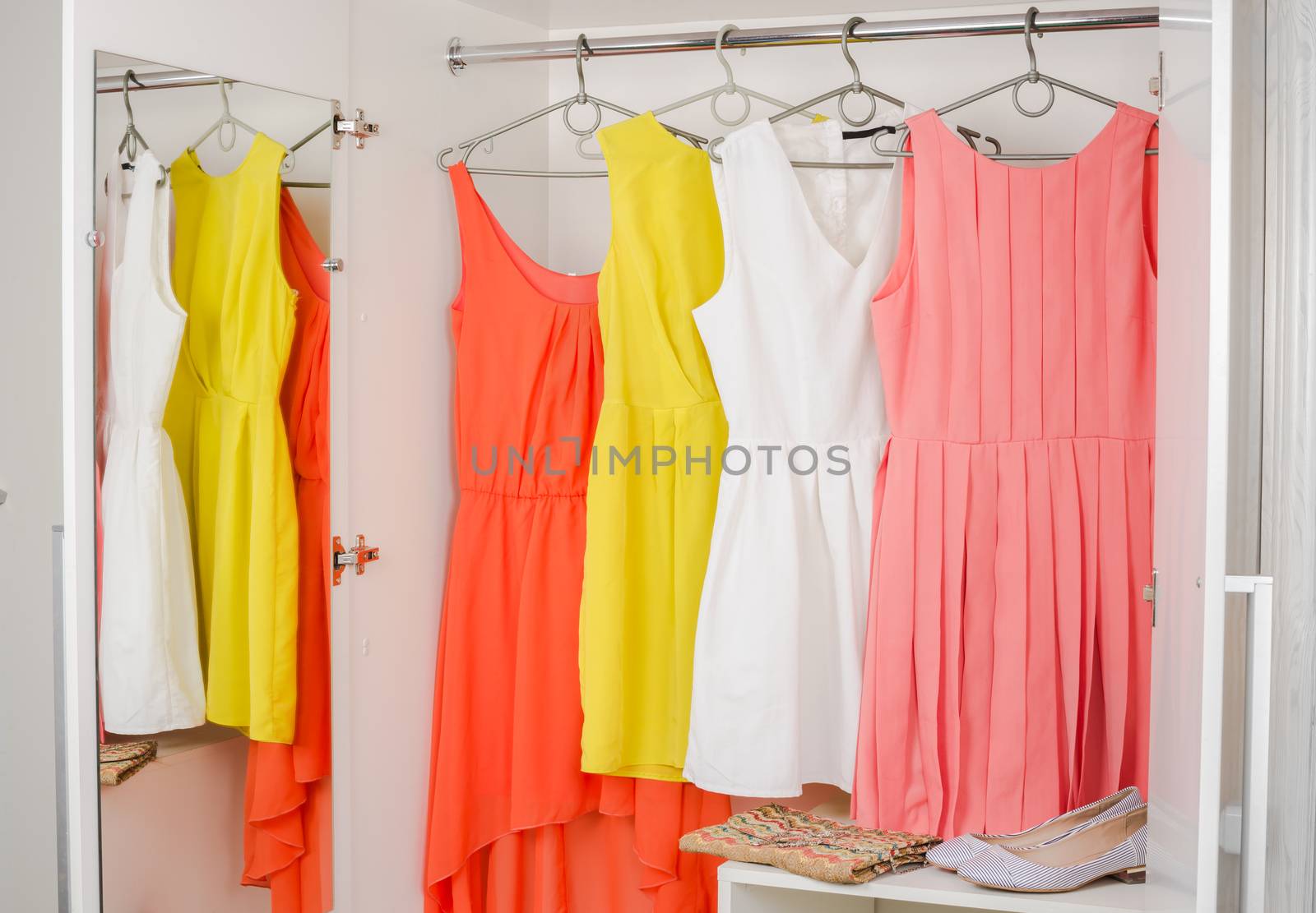  bright colorful dress hanging on coat hanger by iprachenko