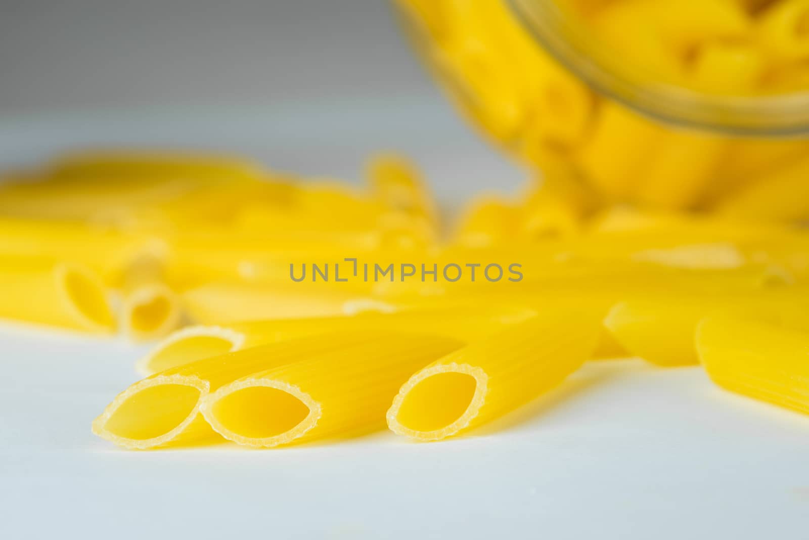 Italian Penne Rigate Macaroni Pasta, raw food, a glass jar, close up