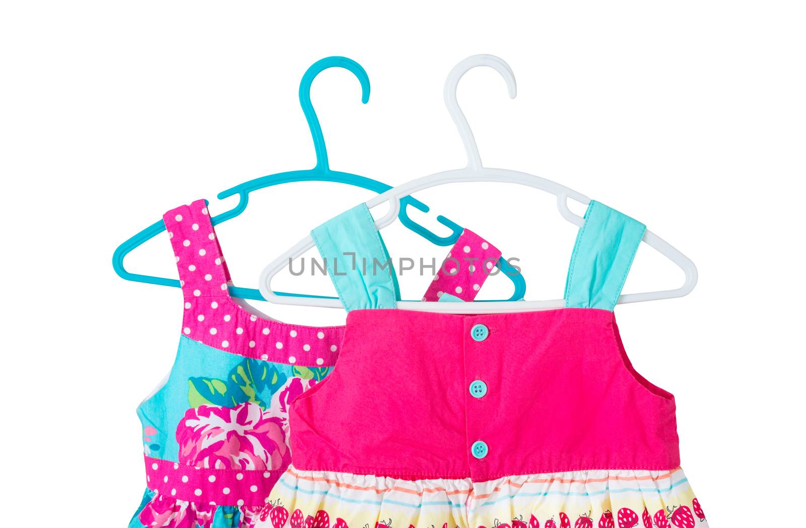 two bright colorful children dresses on coat hanger isolated on white background