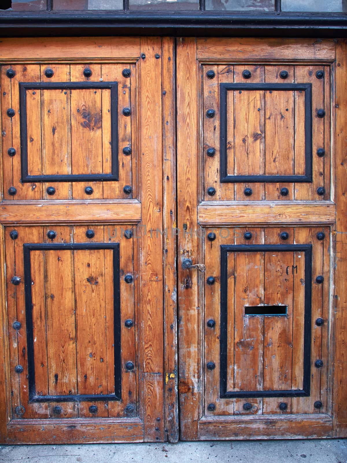 Old vintage decorated wooden brown door as an entry to a city house