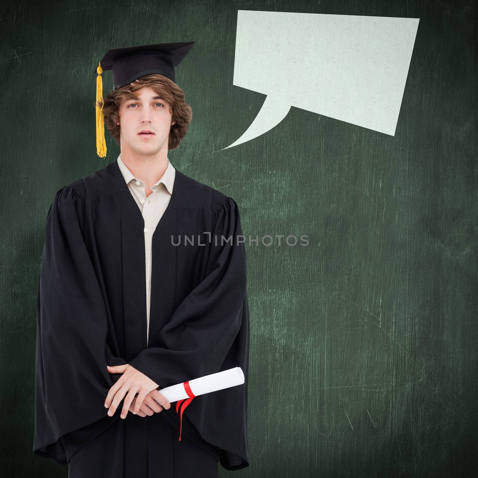 Student in graduate robe against green chalkboard