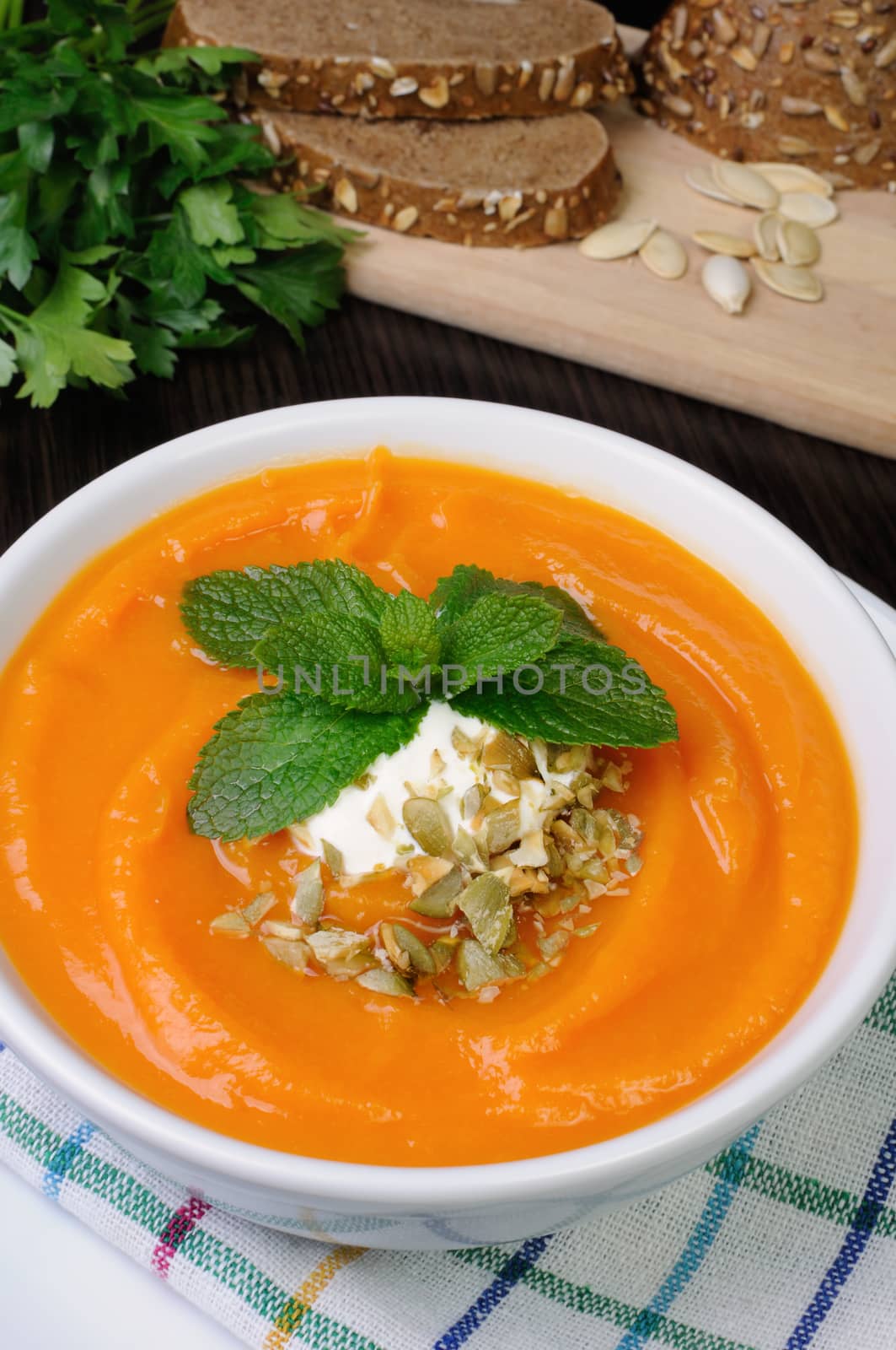 Pumpkin soup with sour cream sauce flavored  pumpkin seeds  and mint