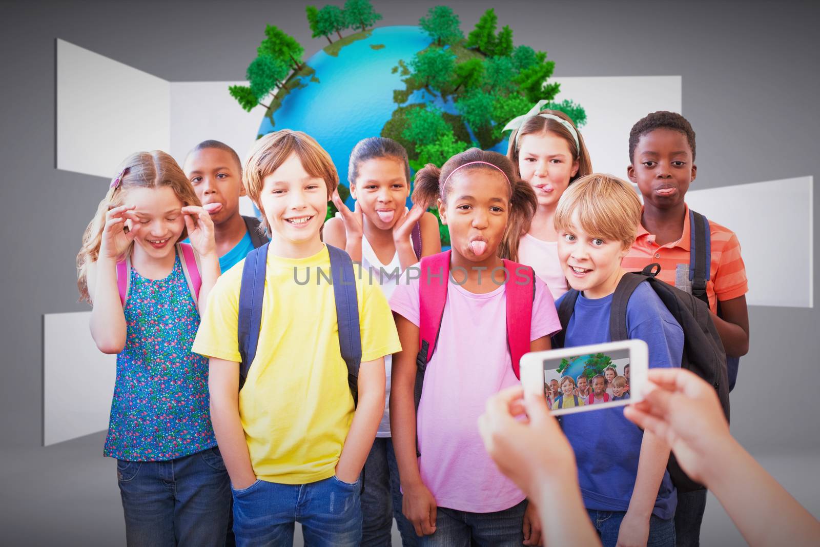 Cute pupils using mobile phone  against earth on abstract grey background