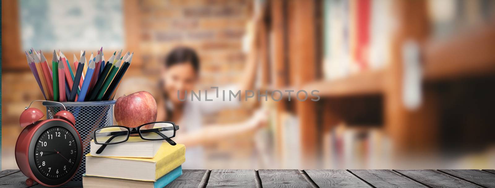 School supplies on desk against teacher and little girl selecting book in library