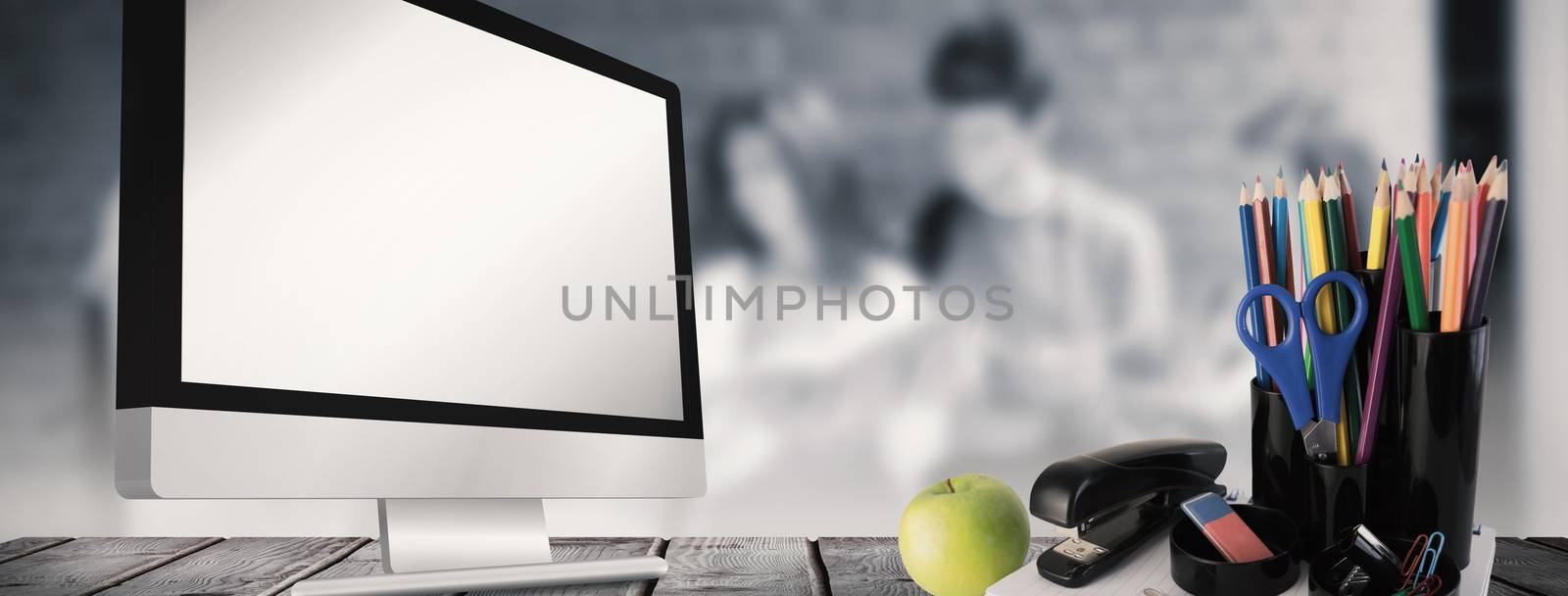 School supplies on desk against happy students standing and reading