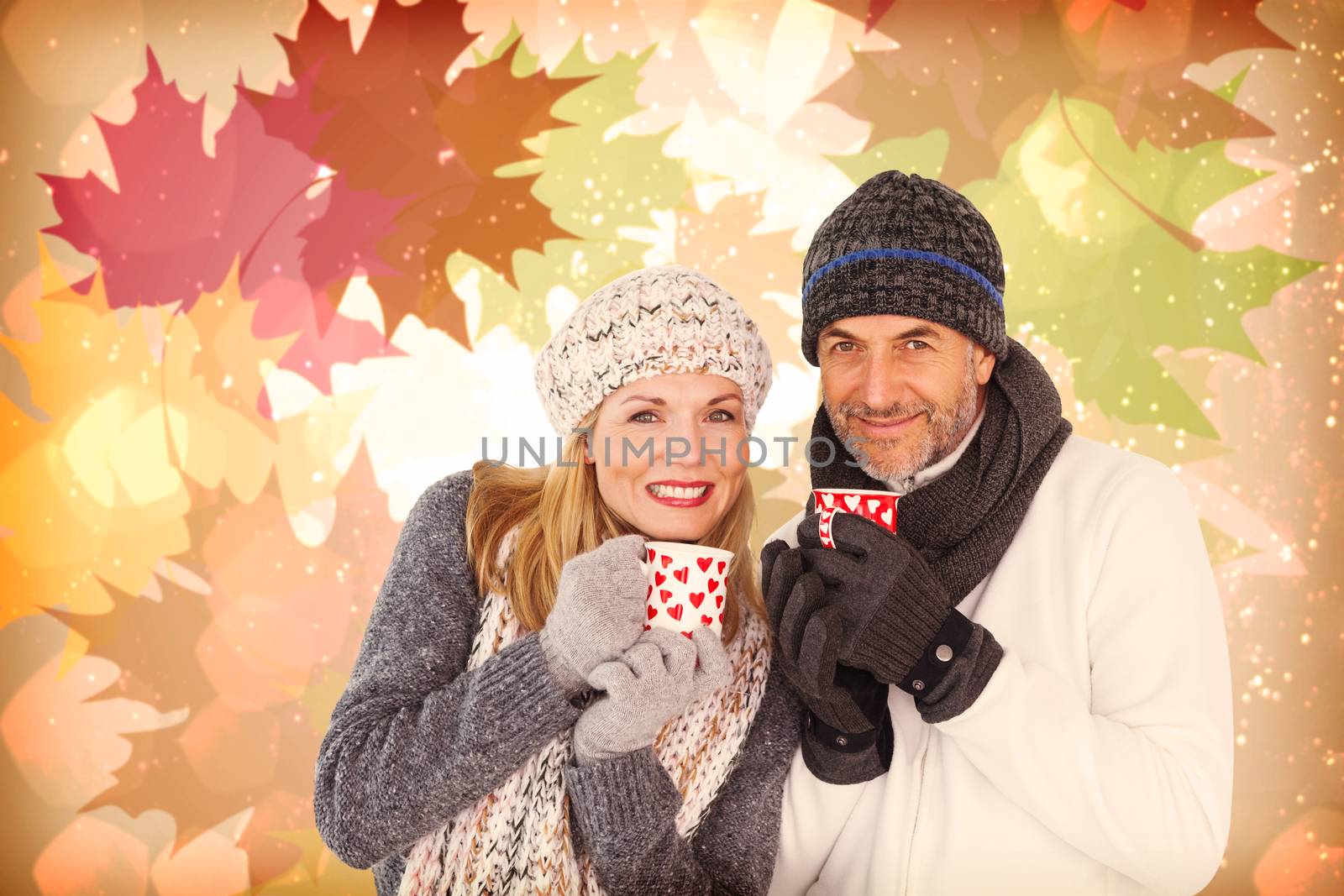 Portrait of couple drinking hot coffee against autumnal leaf pattern in warm tones