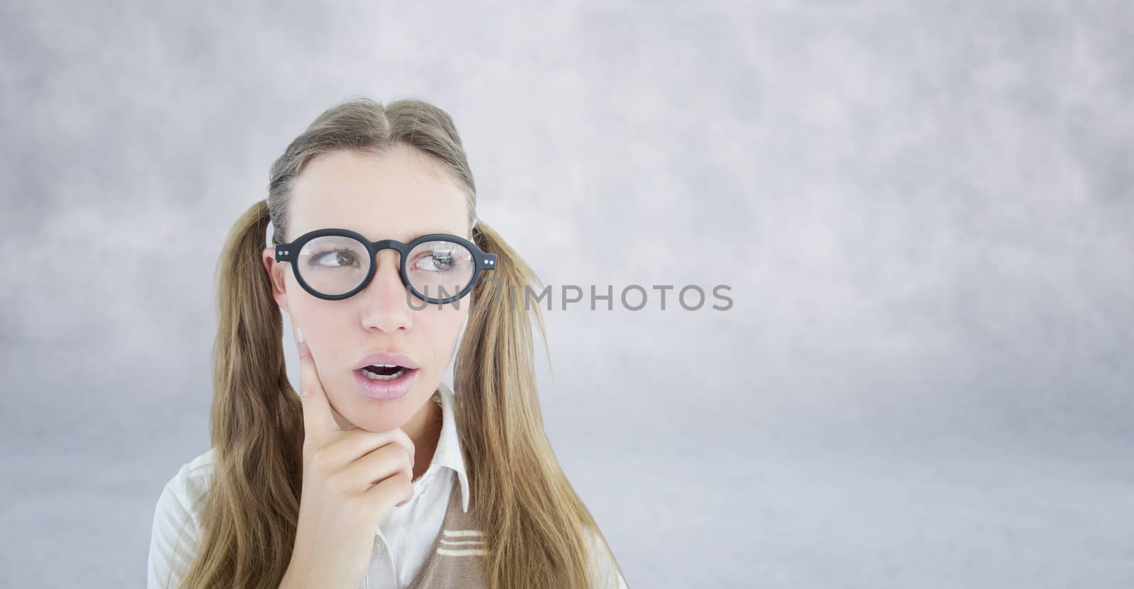 Female geeky hipster looking confused  against grey wall