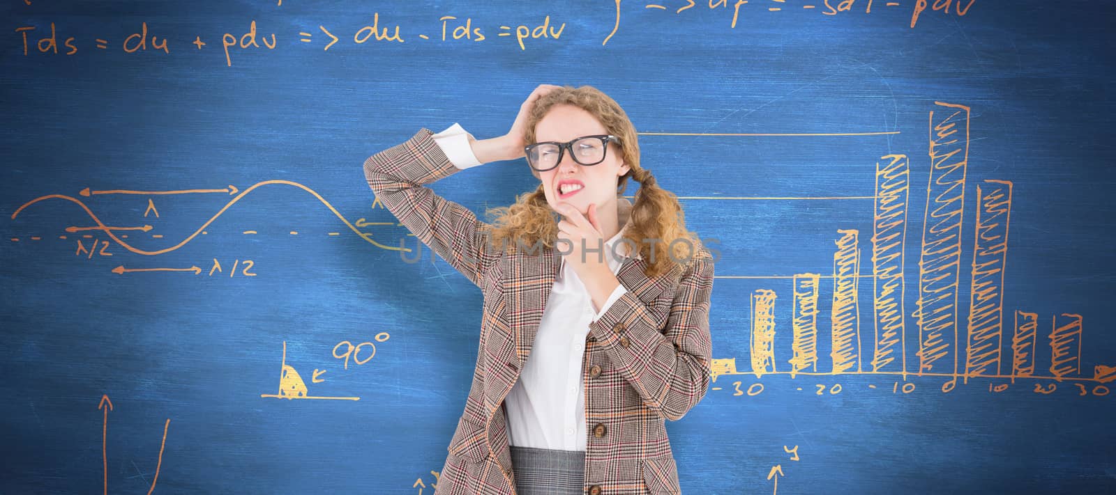 Geeky hipster thinking with hands on chin and temple against blue chalkboard