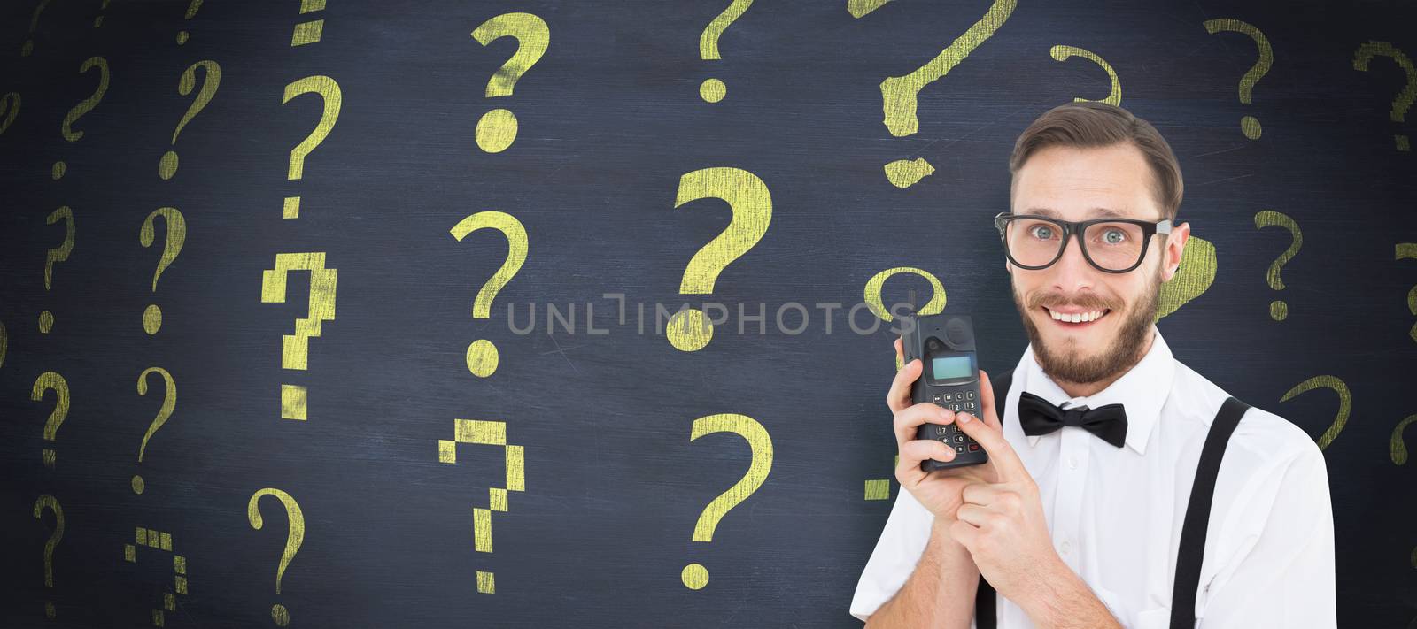 Geeky hipster holding a retro cellphone against blackboard