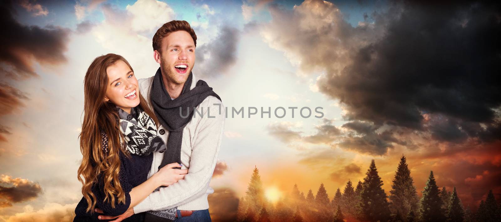 Happy young couple embracing against country scene