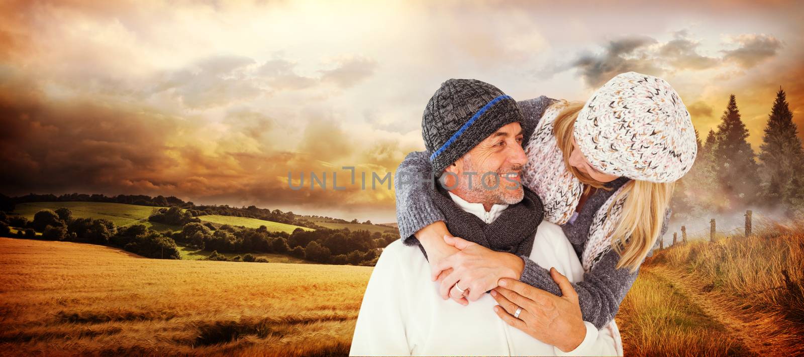 Happy cute couple romancing while embracing each other against country scene