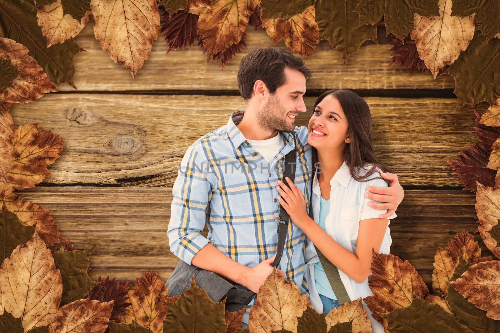 Attractive young couple going on their holidays against wooden background