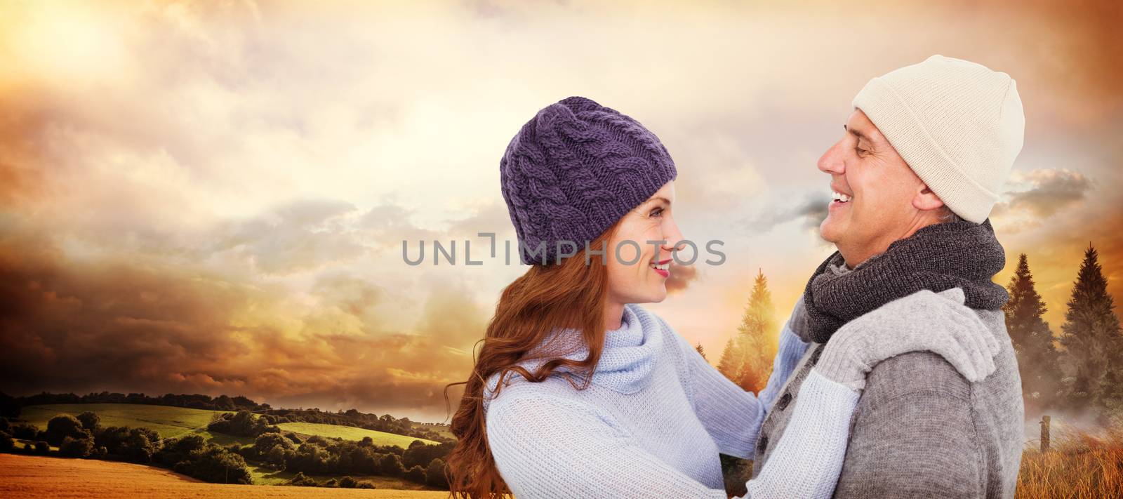 Happy couple in warm clothing against country scene