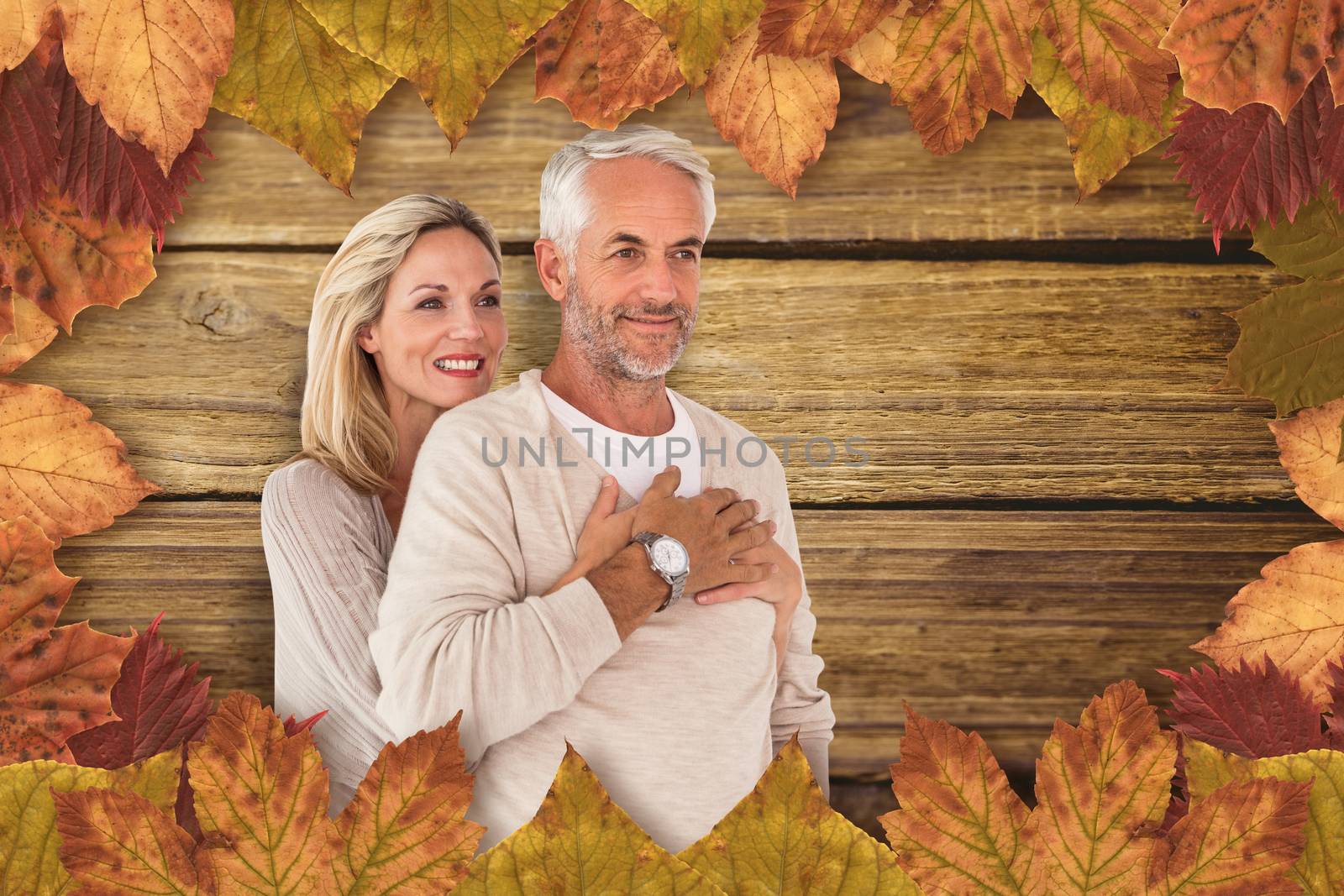 Cheerful wife embracing husband against wooden background