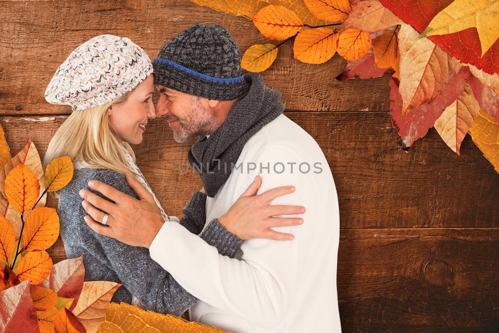 Smiling cute couple romancing over white background against overhead of wooden planks