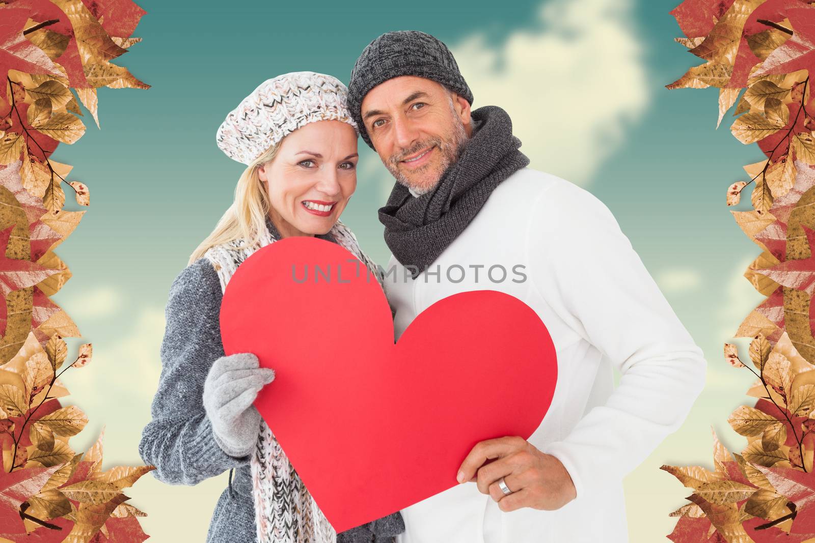 Portrait of happy couple holding heart against blue sky