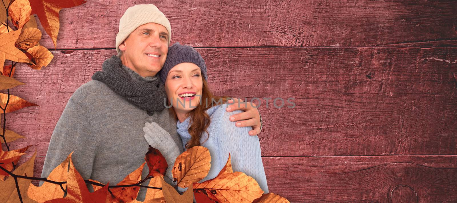 Composite image of couple in warm clothing embracing by Wavebreakmedia