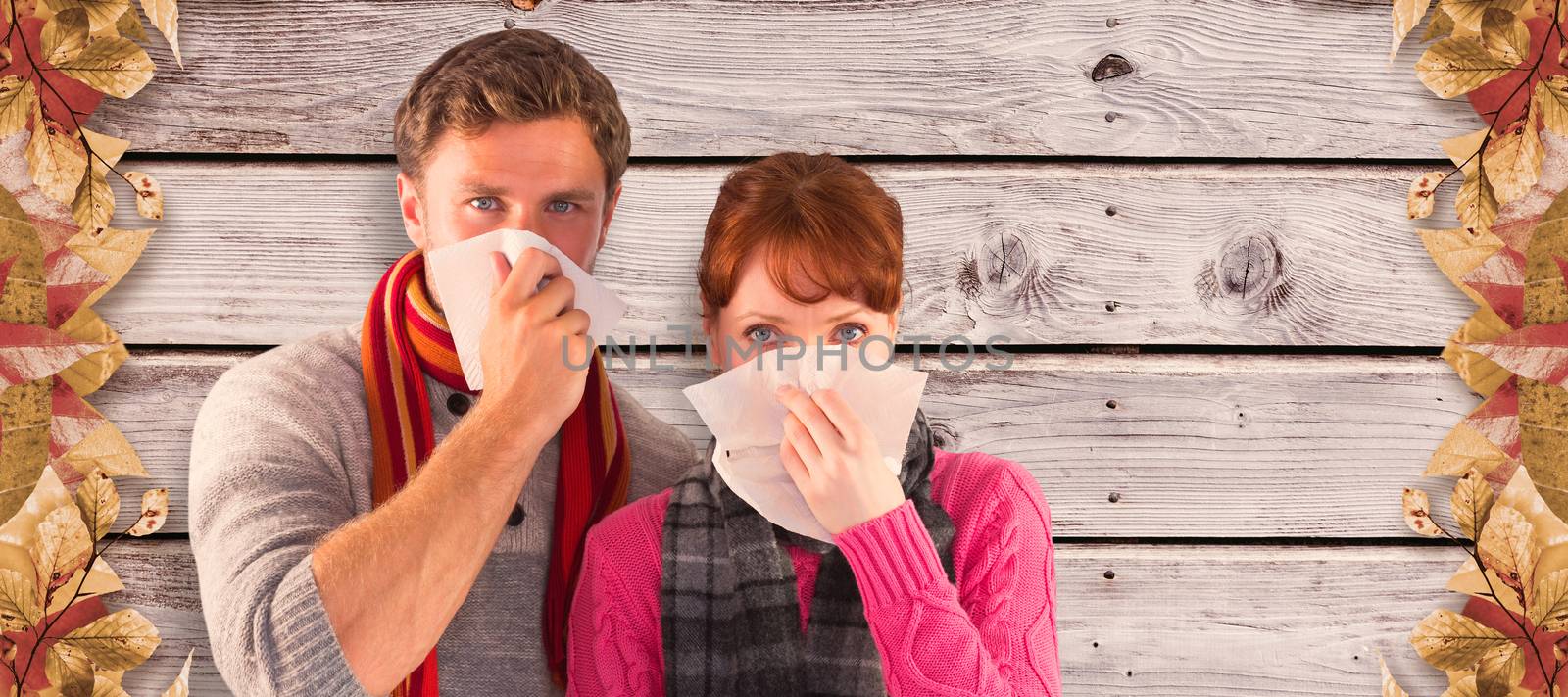 Couple blowing noses into tissues against digitally generated grey wooden planks