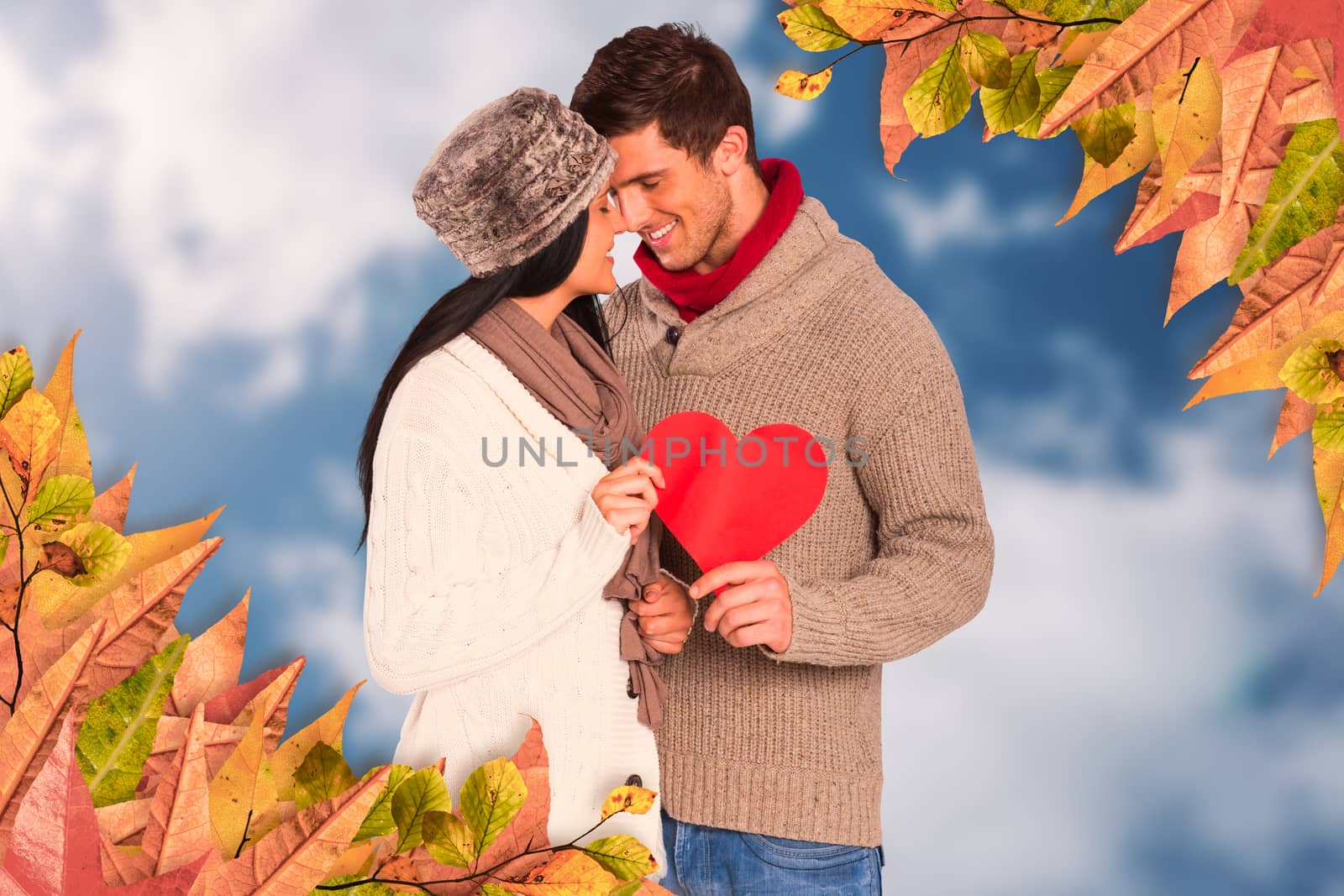 Young couple smiling and hugging against bright blue sky with clouds