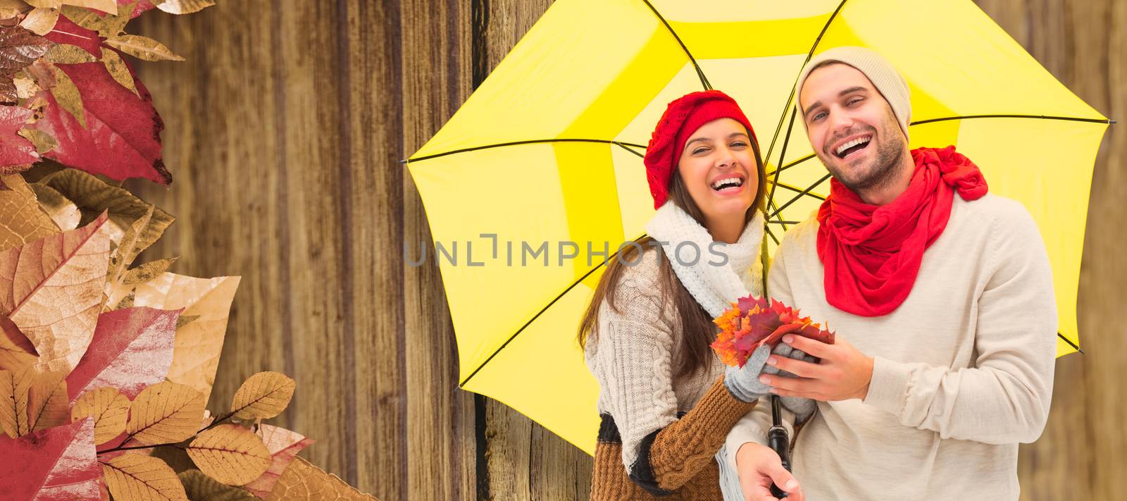 Autumn couple holding umbrella against close-up of wooden plank