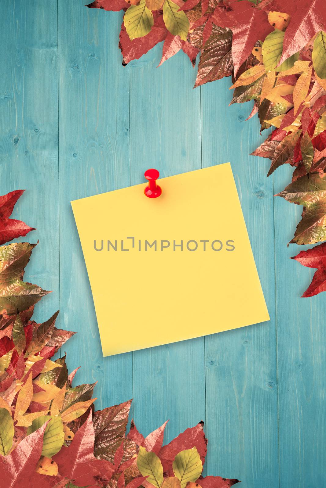 Illustrative image of pushpin on yellow paper  against autumn leaves pattern