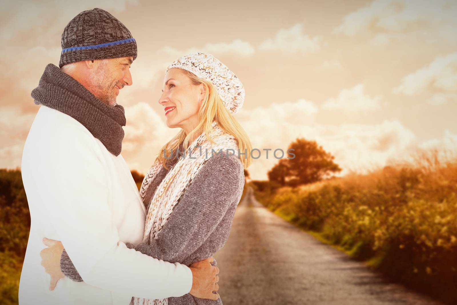 Happy husband holding wife while looking at each other against country road