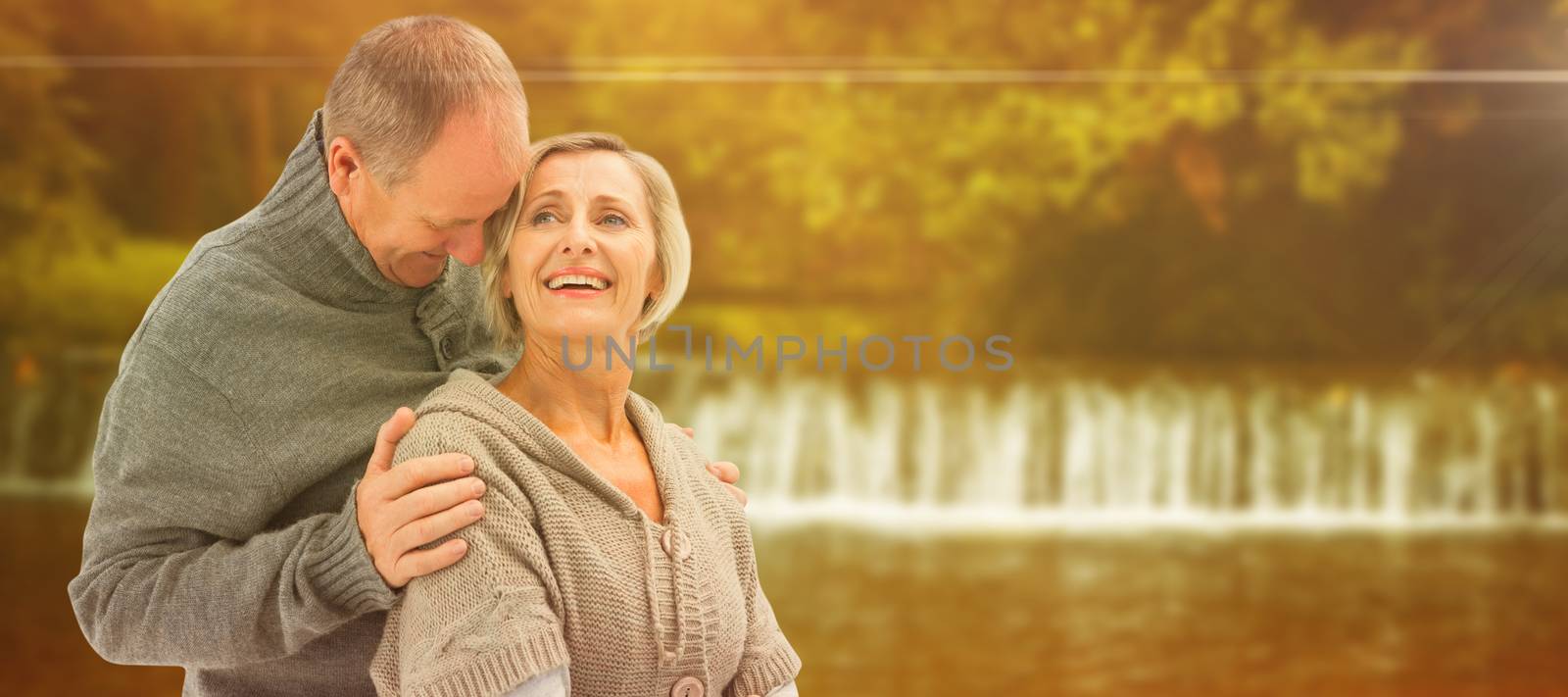 Happy mature couple in winter clothes against autumn scene