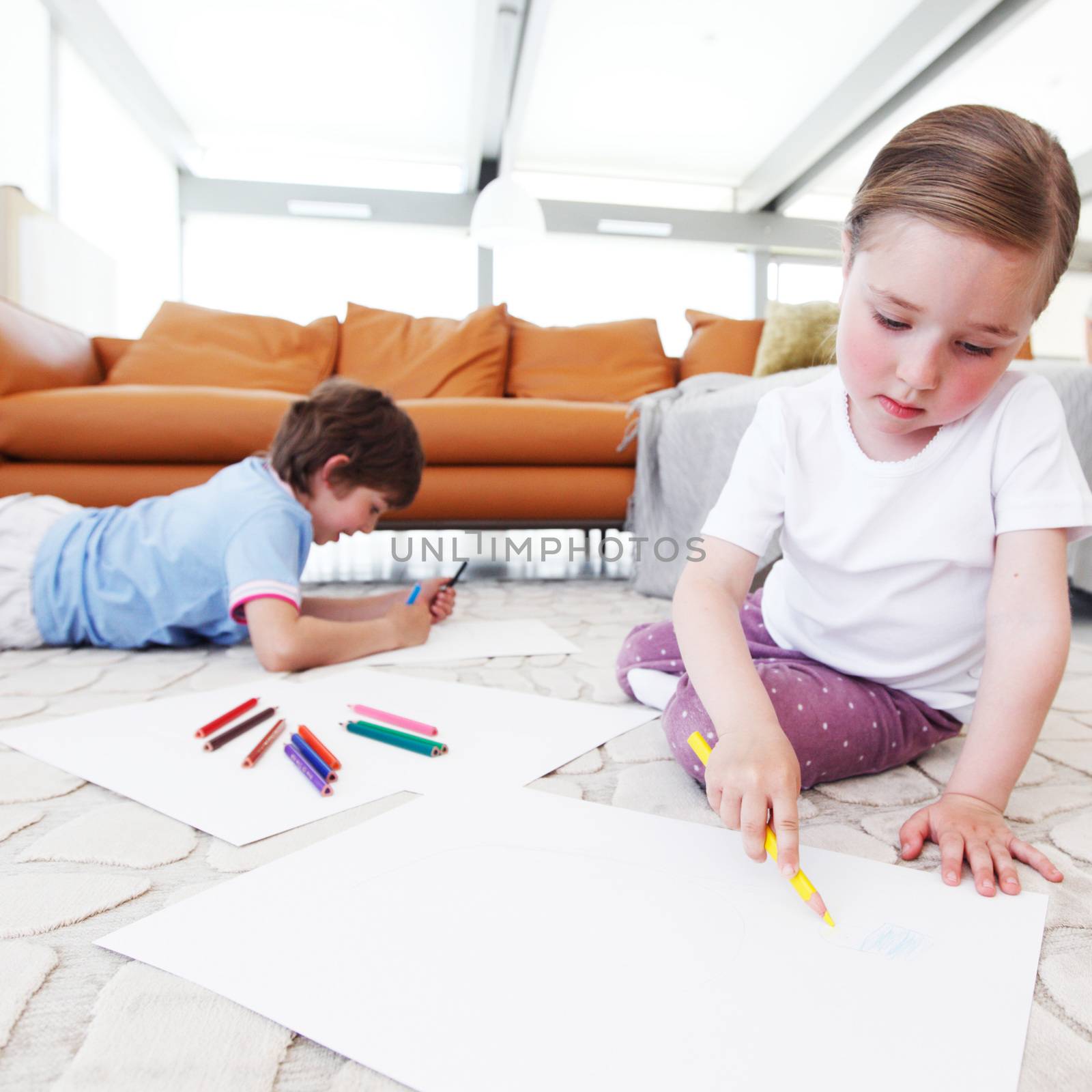 brother and sister drawing pictures with coloring pencils