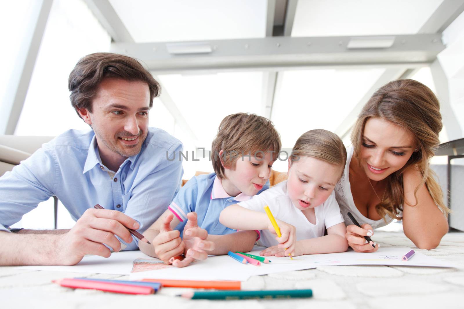 happy family drawing pictures with coloring pencils