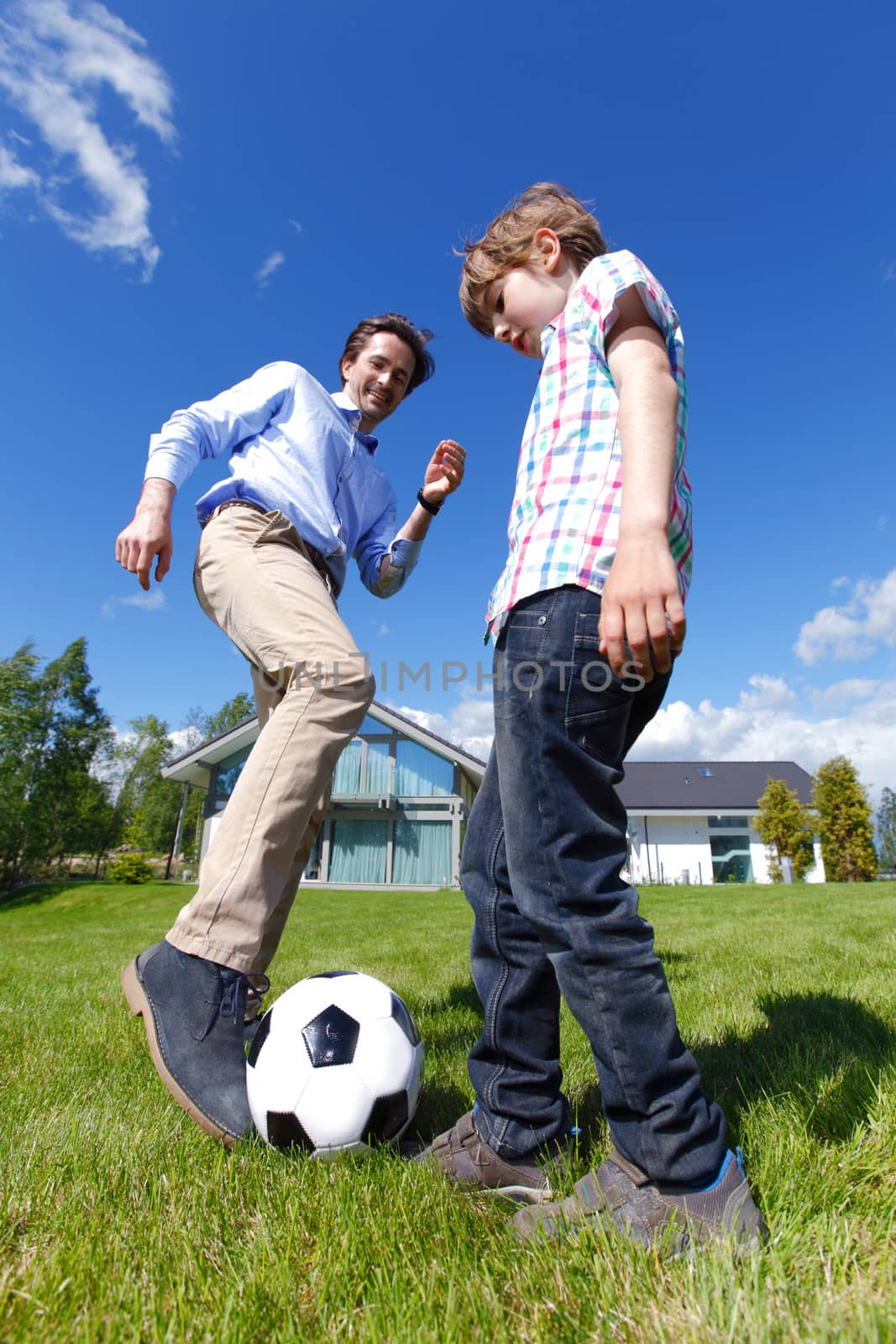 father and son playing football by ALotOfPeople