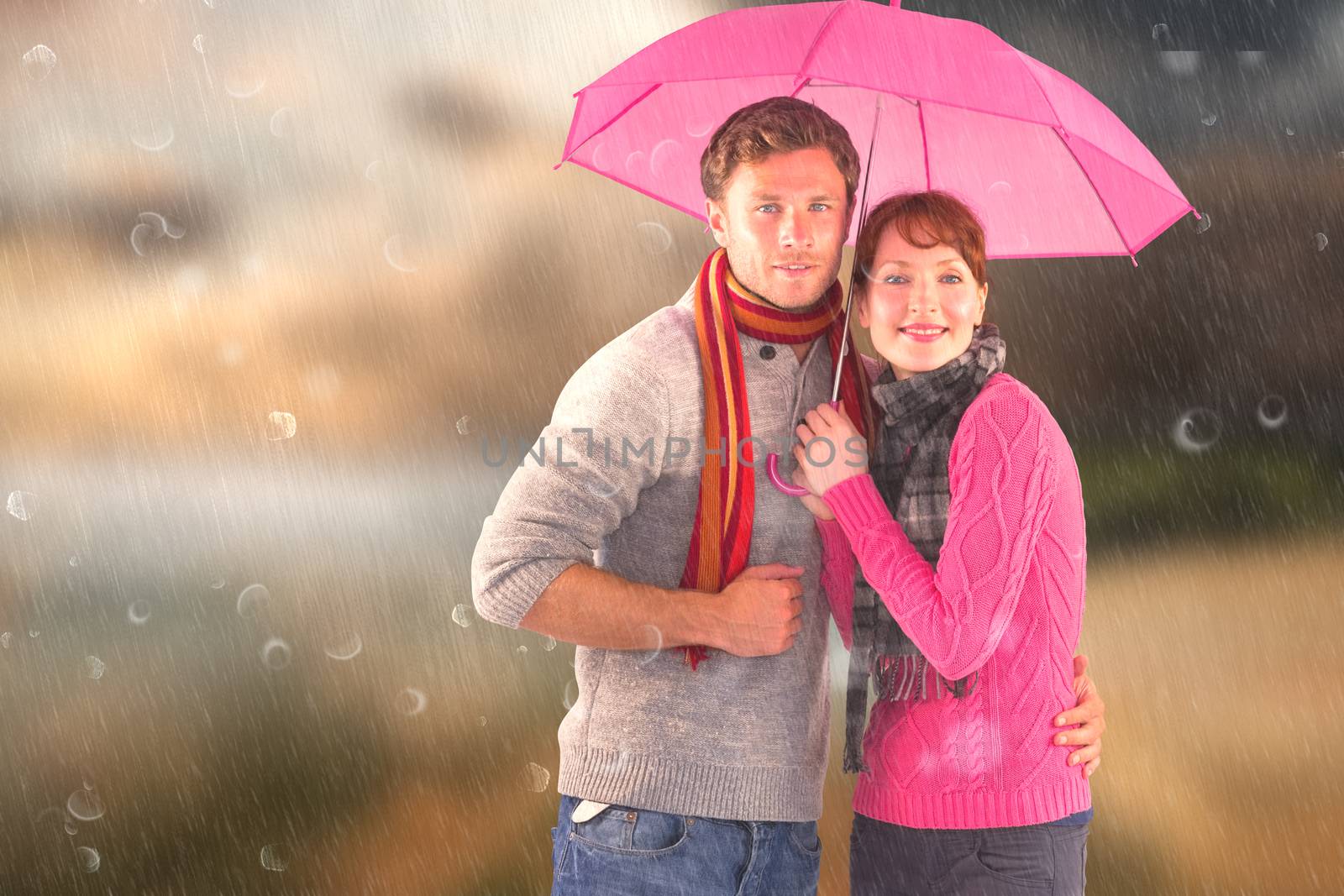 Couple standing underneath an umbrella against country scene