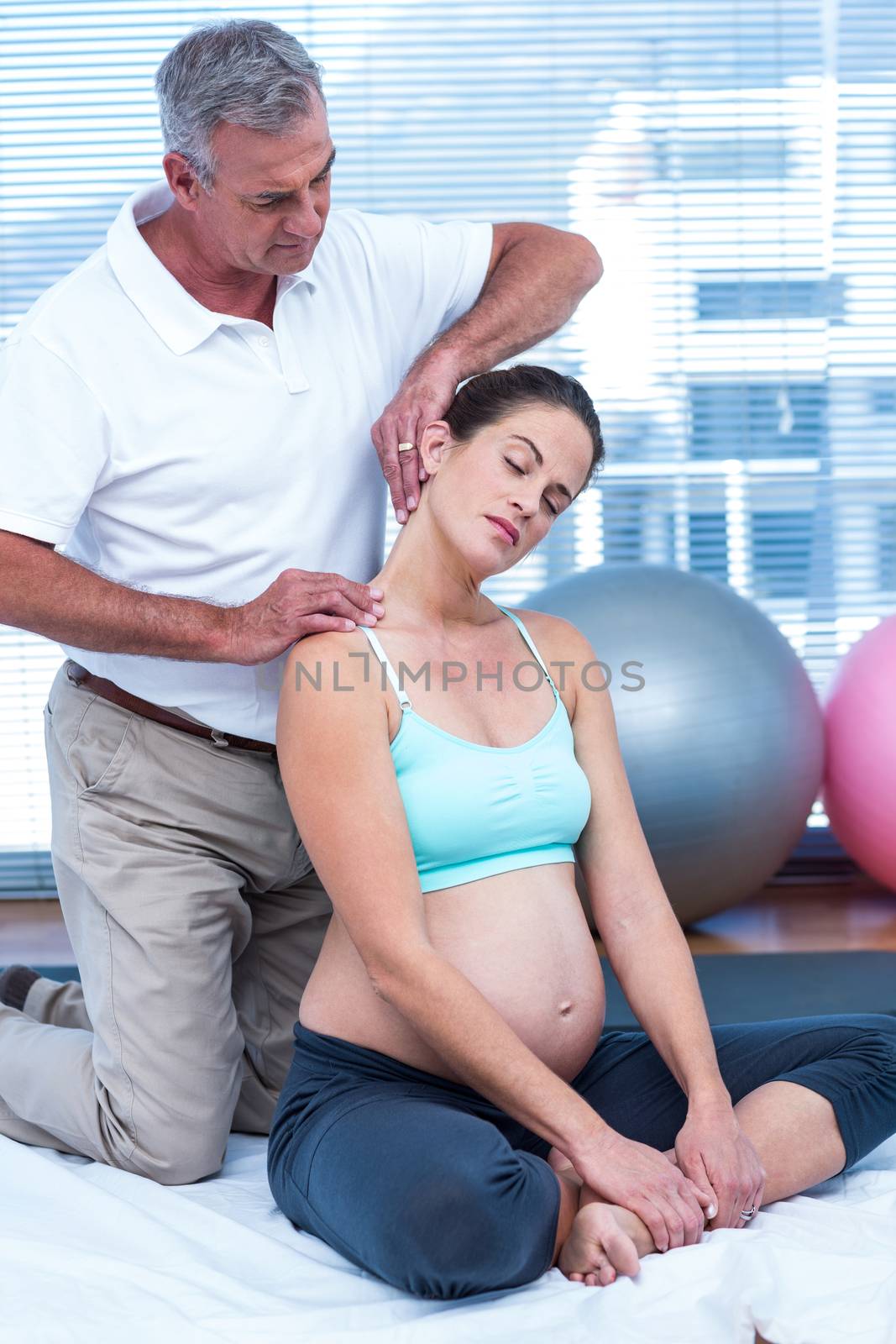 Pregnant woman in gym with trainer by Wavebreakmedia