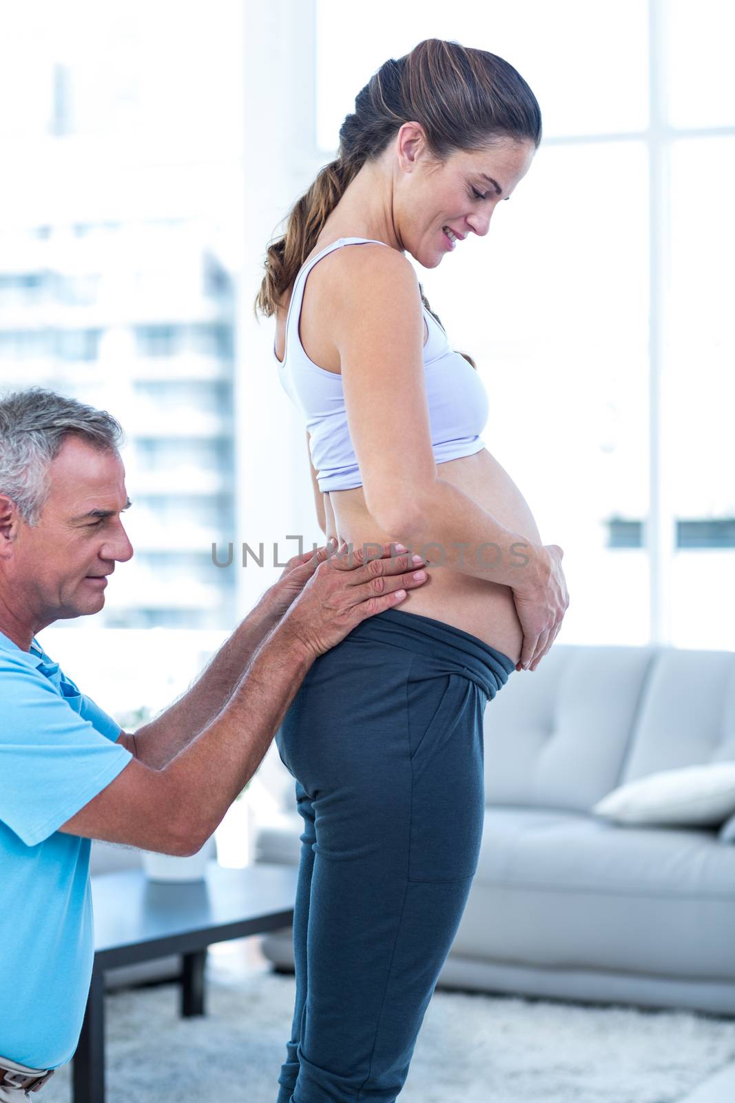 Pregnant woman getting massage while standing at home